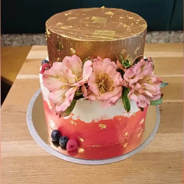 Zweistöckige Festtorte mit Blattgold, Alstroemerien und frischen Beeren vom Café am Markt in Jena