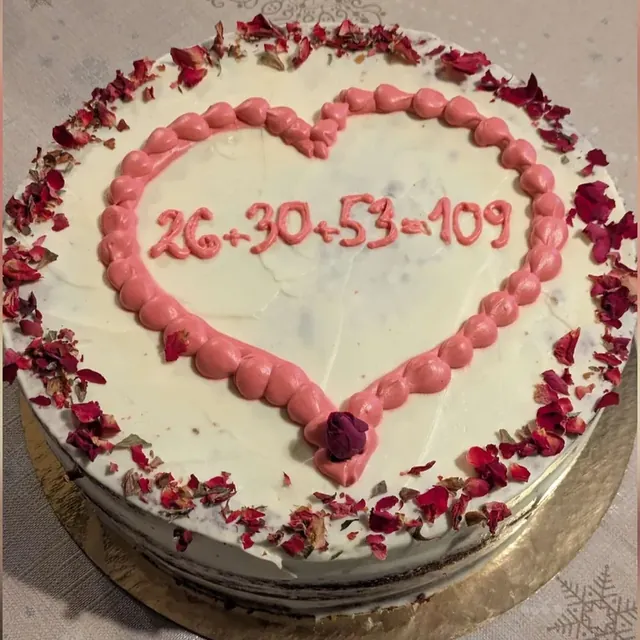Torte mit rosa Herzrand, getrockneten Rosenblüten und Zahlen-Schriftzug zum gemeinsamen Geburtstag aus der Patisserie in Jena
