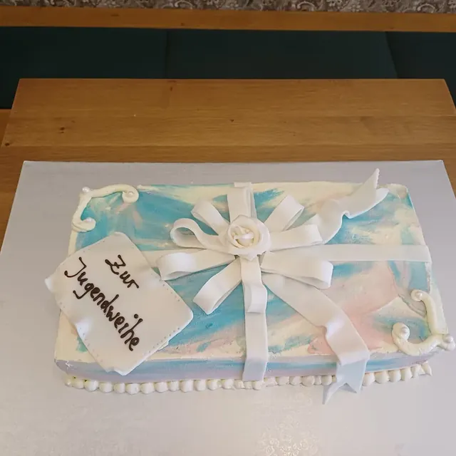 Blechtorte in Geschenkform mit weißer Fondantschleife zur Jugendweihe aus der Konditorei in Jena