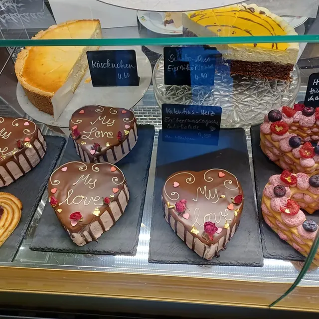 Valentinstags-Herztorten mit Schokolade, Rosen und Beeren in der Theke des Café am Markt in Jena