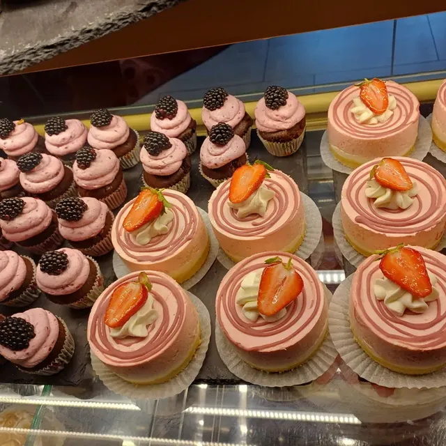 Cupcakes mit Brombeeren und Erdbeer-Törtchen in der Vitrine des Café am Markt in Jena