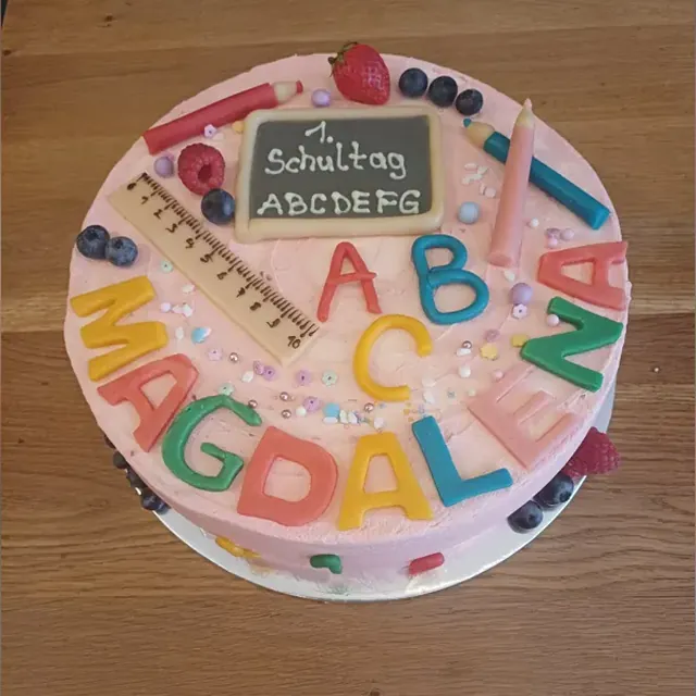 Runde Einschulungstorte mit Marzipan-Tafel, ABC-Buchstaben und Stiften aus der Patisserie in Jena