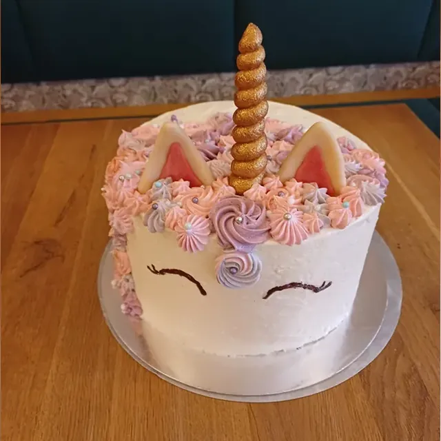 Einhorntorte mit goldenem Horn, Marzipanohren und pastellfarbenen Cremetupfen vom Café am Markt in Jena