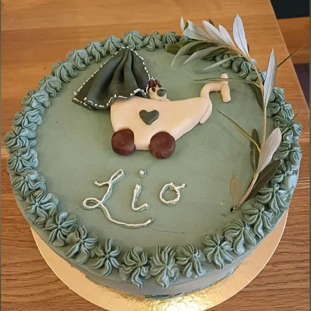Grüne Torte mit Kinderwagen-Motiv und Olivenzweig zur Geburt vom Café am Markt in Jena
