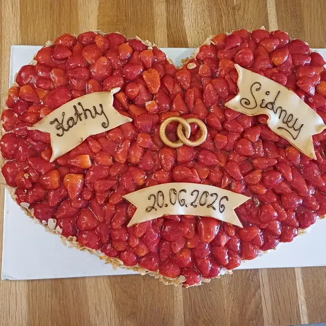 Herzförmige Erdbeertorte mit Marzipanbannern und goldenen Ringen zur Hochzeit vom Café am Markt in Jena