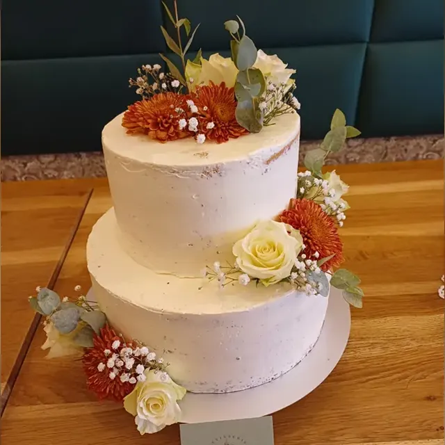 Zweistöckige Semi-Naked-Hochzeitstorte mit Chrysanthemen, Rosen und Eukalyptus aus der Patisserie in Jena
