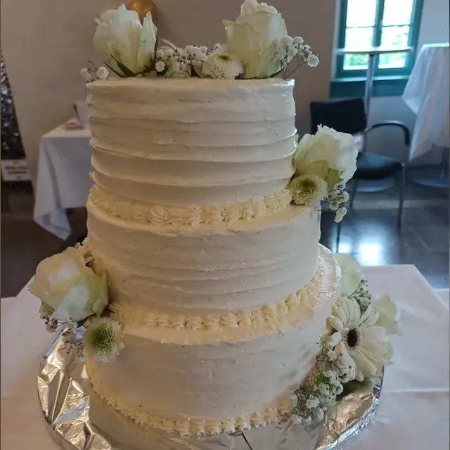 Dreistöckige klassische Hochzeitstorte in Weiß mit Rosen und Gerbera vom Café am Markt in Jena