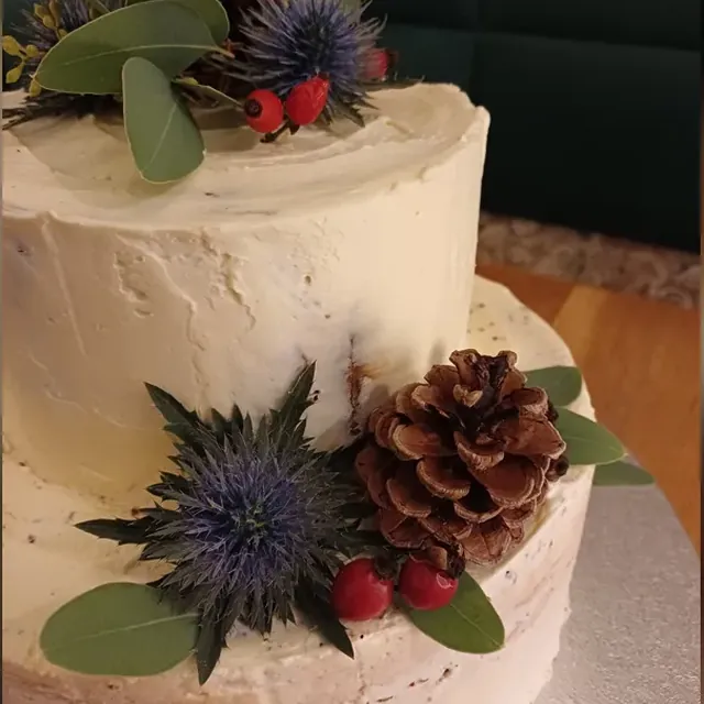 Zweistöckige winterliche Hochzeitstorte mit Zapfen, Disteln und Hagebutten aus der Konditorei in Jena