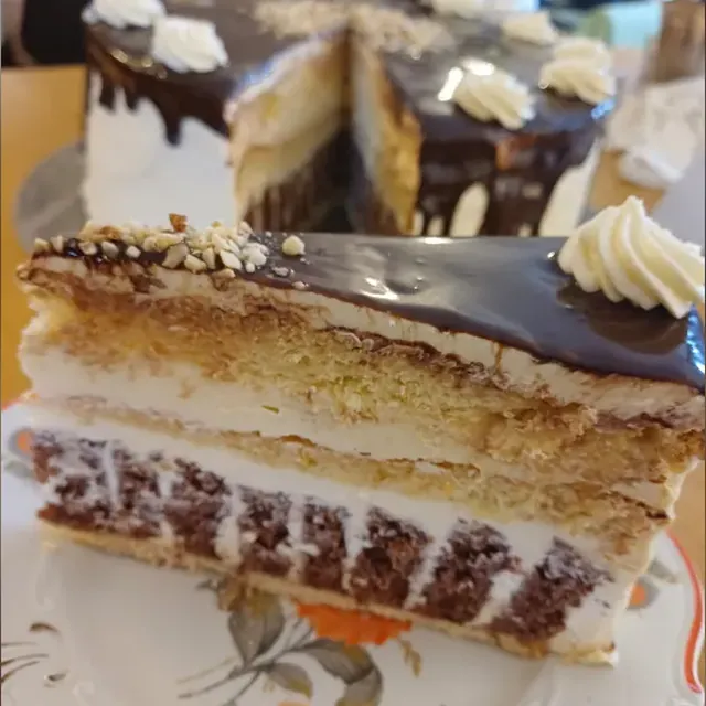 Angeschnittene Schichttorte mit Sahne, Nüssen und Schokoladenglasur aus der Konditorei in Jena