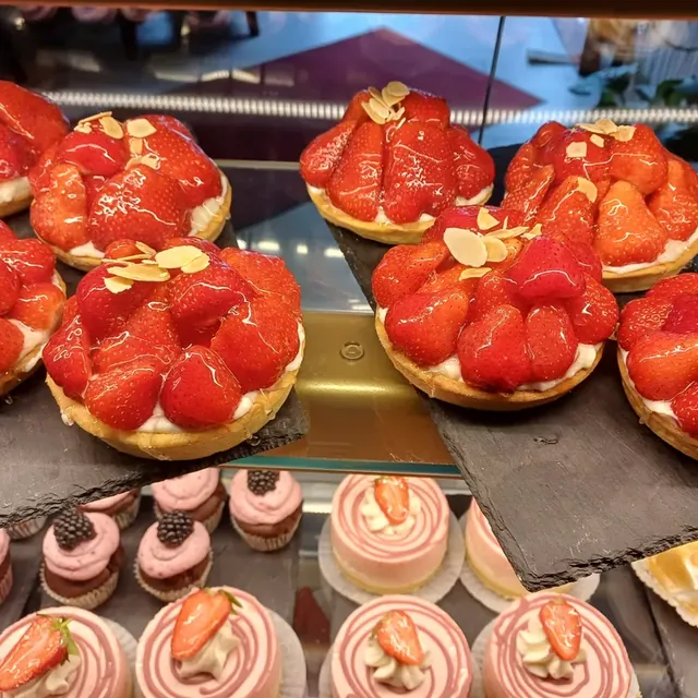 Tartlets mit glasierten Erdbeeren, Vanillecreme und Mandelblättchen in der Vitrine in Jena