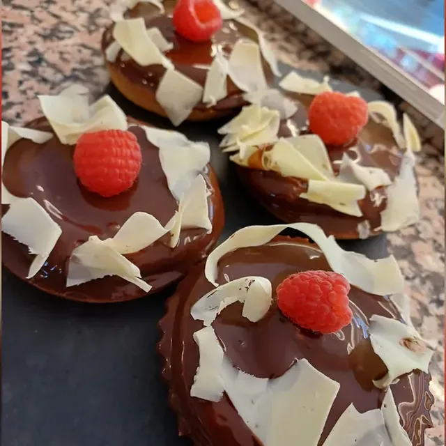 Tartlets mit Schokoladenganache, weißen Schokoladenspänen und Himbeere aus der Patisserie in Jena