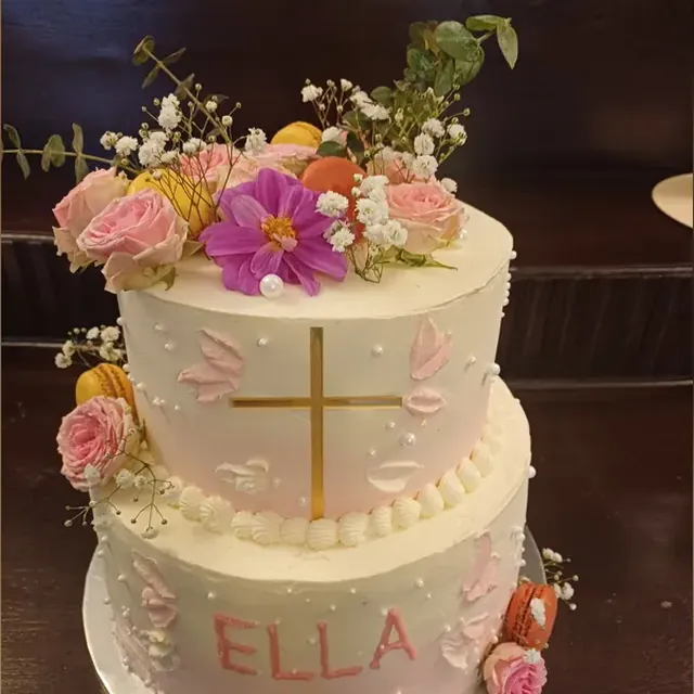 Zweistöckige Tauftorte mit goldenem Kreuz, Rosen und Macarons vom Café am Markt in Jena