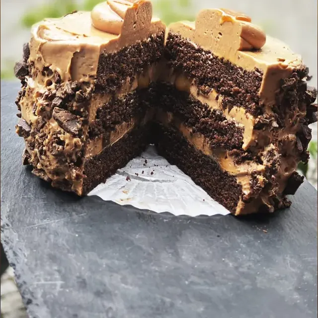Hausgemachte Schokoladentorte mit Karamellcreme, angeschnitten, aus der Konditorei in Jena